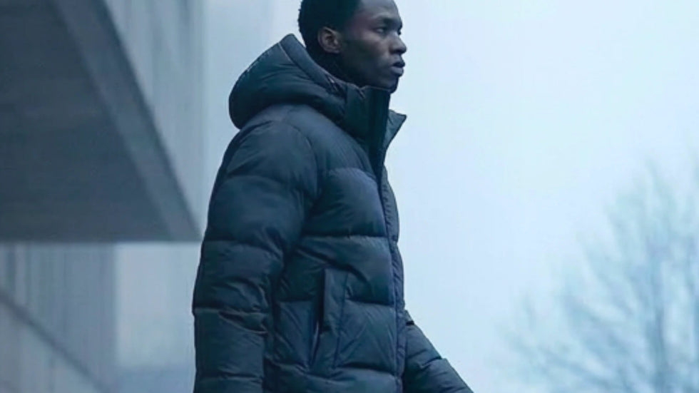 Person wearing a dark coat in a foggy urban setting
