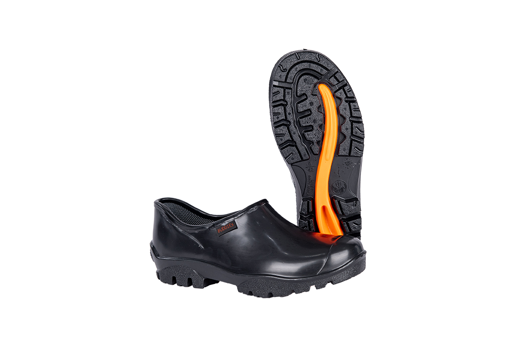 Black PVC safety overshoe with slip-resistant sole and orange tread, displayed on a white background.