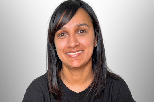 Mr Farmer Workwear staff memebr Amy. with long dark hair wearing a black shirt against a plain background