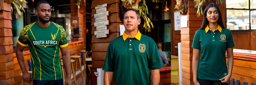Three people wearing South Africa national team rugby jerseys in green and yellow, standing in a restaurant setting with brick walls and wooden decor.